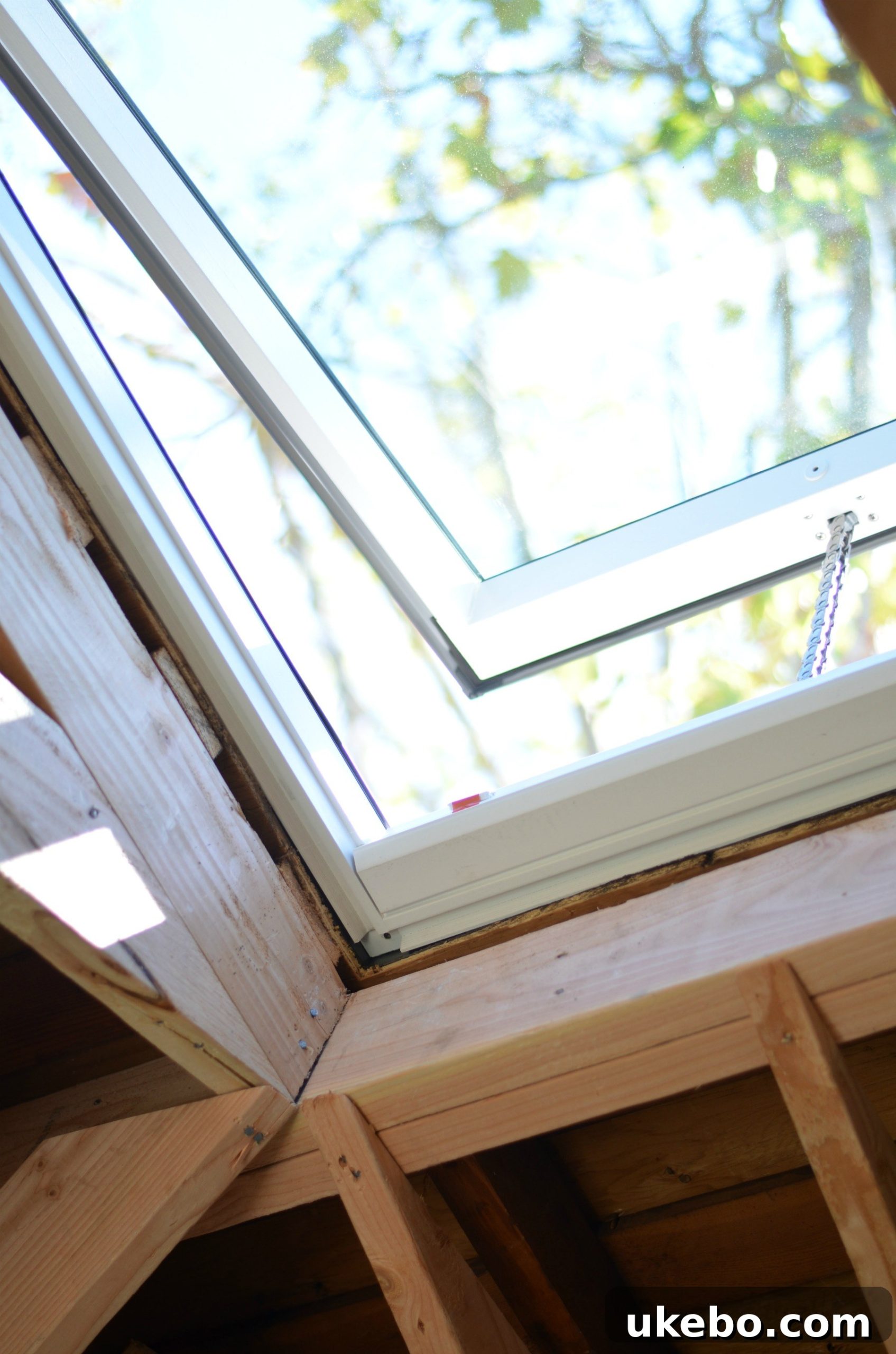 An open Velux skylight in a bathroom, showing fresh air circulating and providing natural light. The bathroom features neutral tones and a modern aesthetic.
