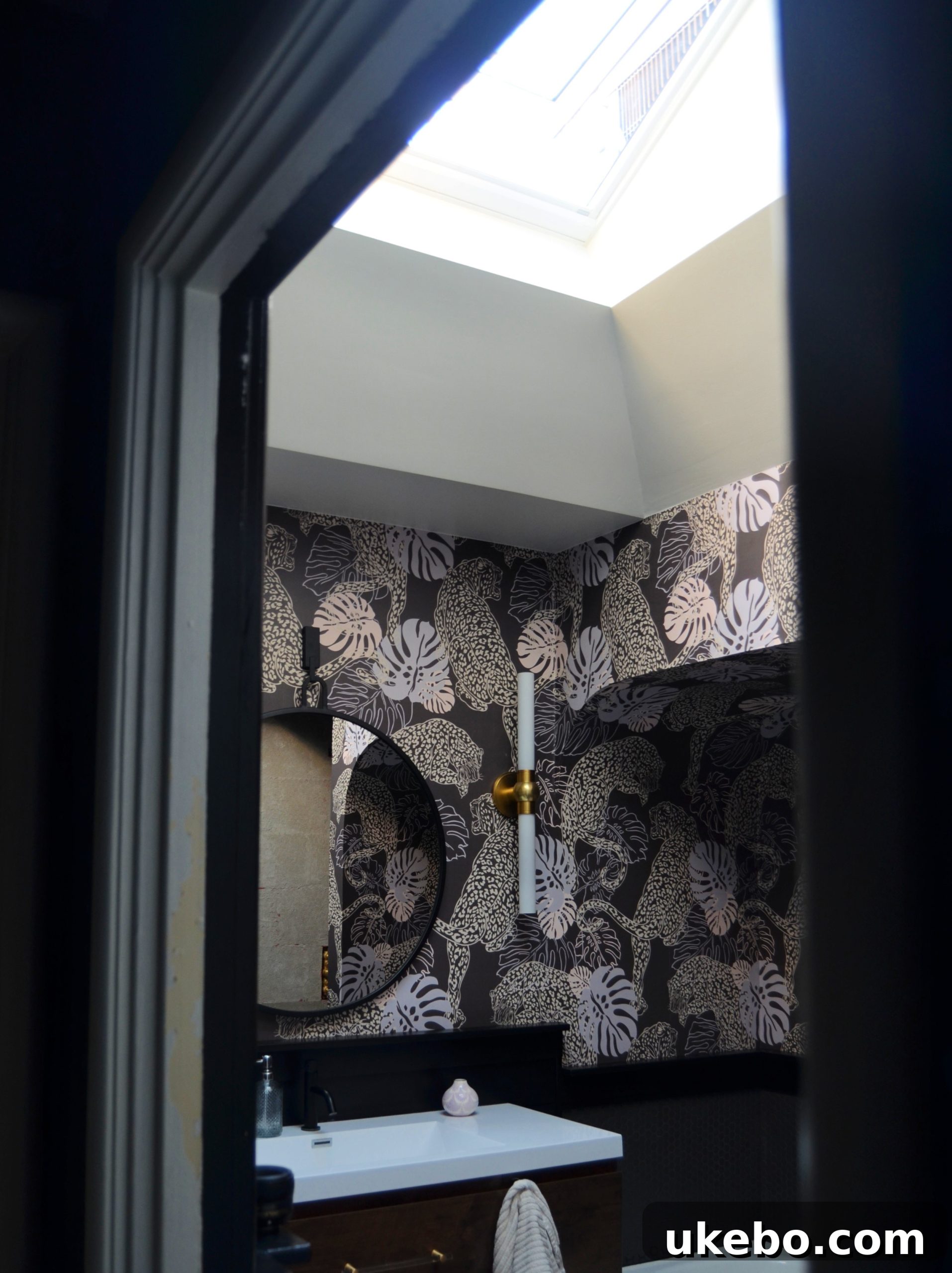 The same bathroom view with the skylight blind open and the skylight raised, flooding the space with bright natural light.