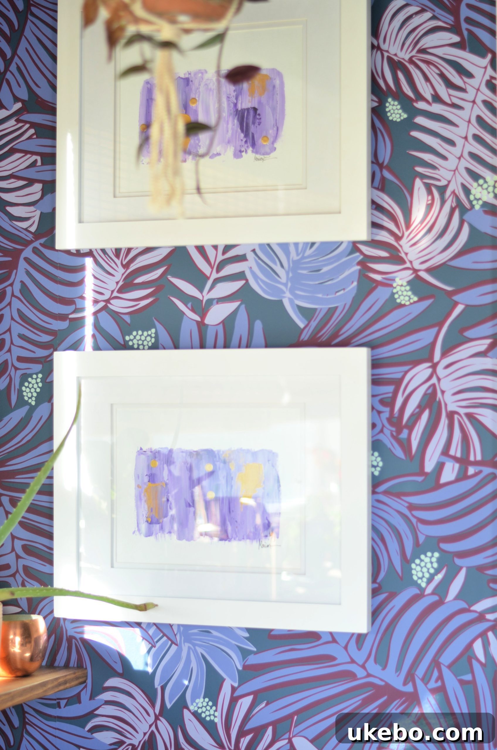 Monica Lewis abstract art hanging above the shelves, complementing the purple tones of the wallpaper.