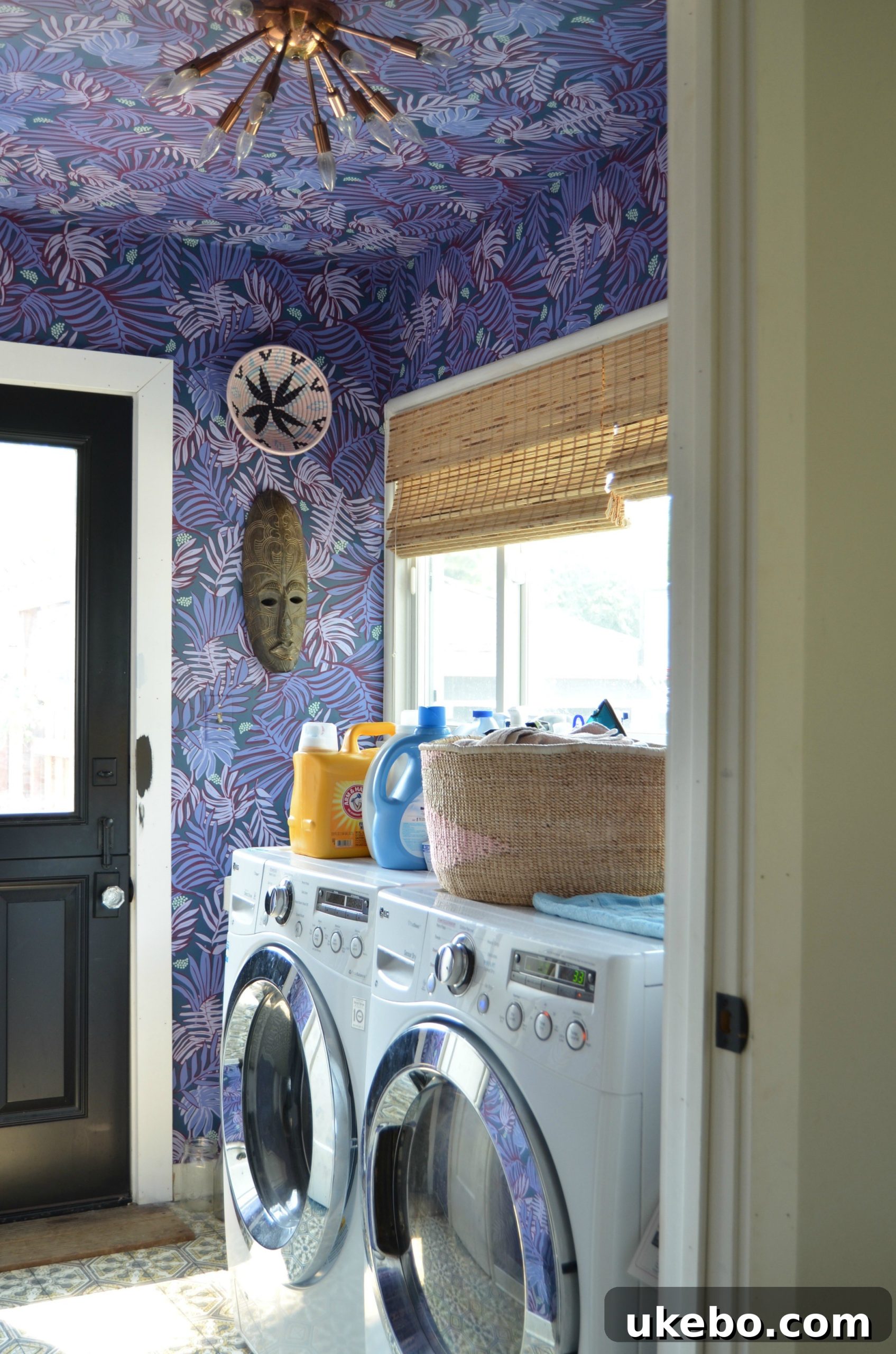 Another view of the renovated laundry room, highlighting the cheerful wallpaper and the improved layout.