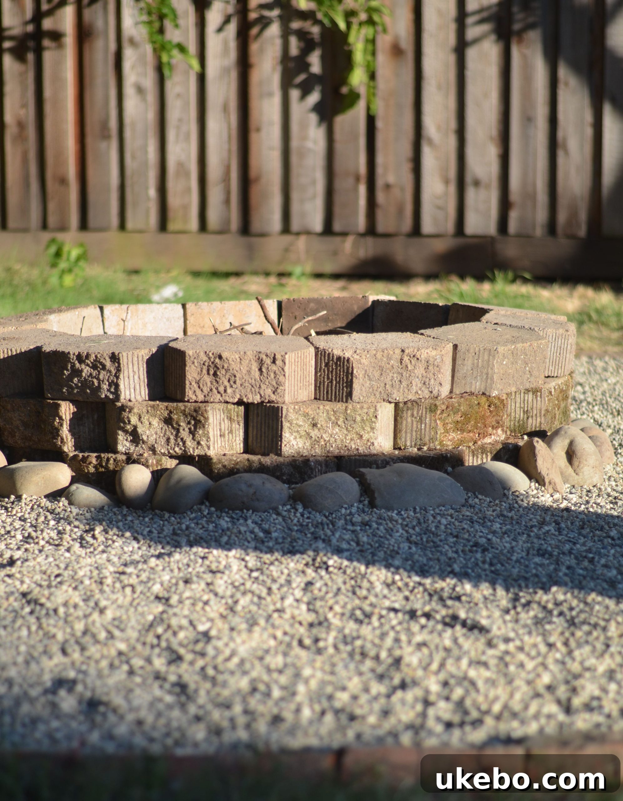 Close-up of the fire pit's intricate rock border and repurposed materials