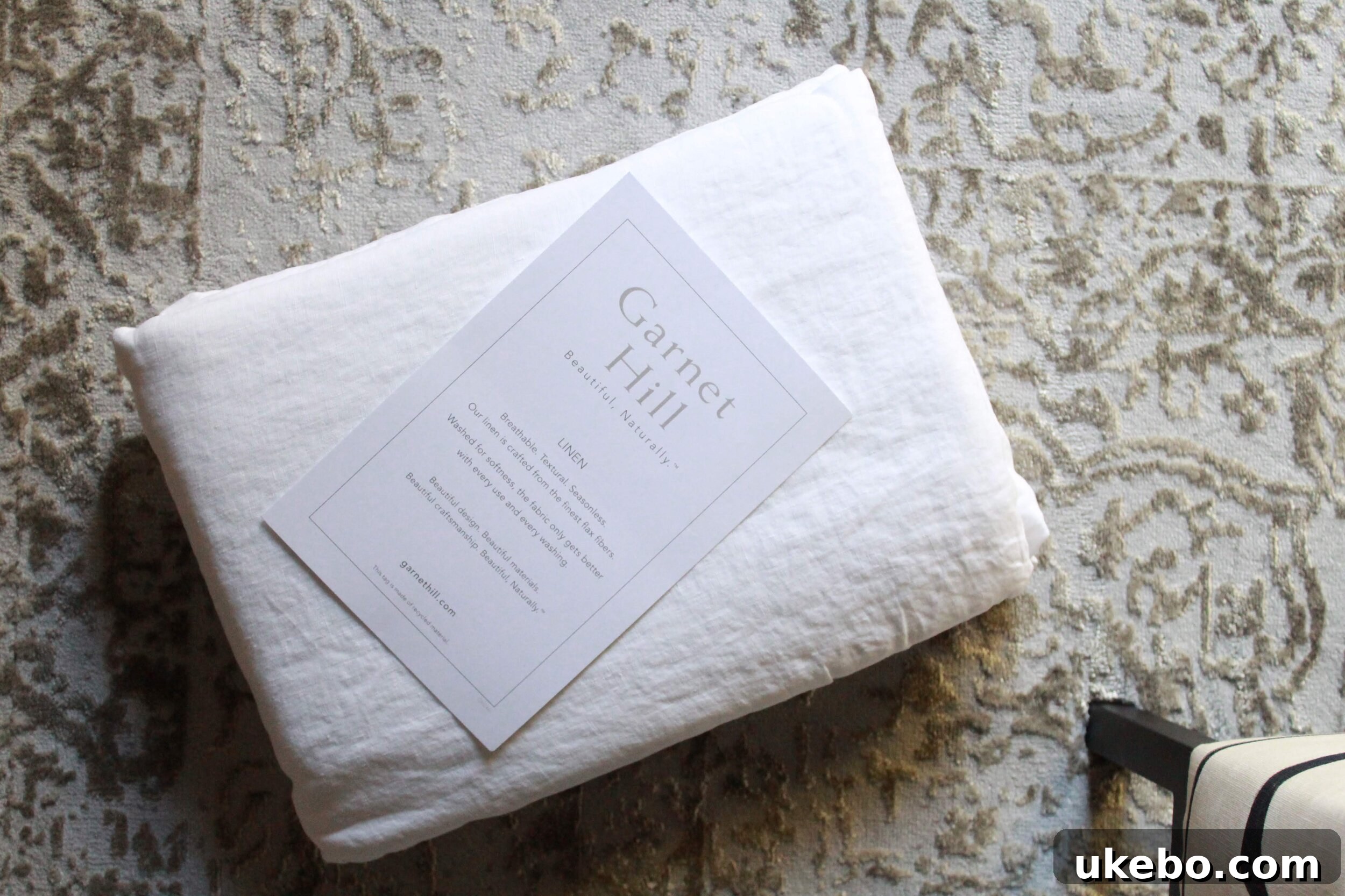 Close-up of the Deva Linen platform bed with crisp white linen bedding from Garnet Hill