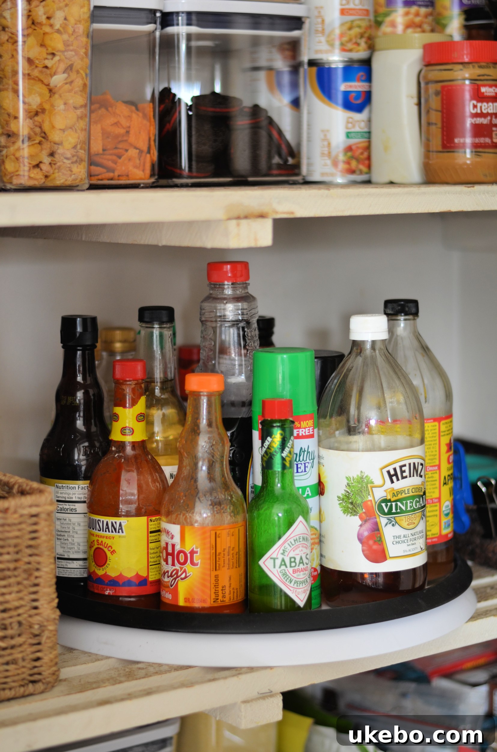 Organized pantry shelf featuring a lazy susan with various oils and sauces