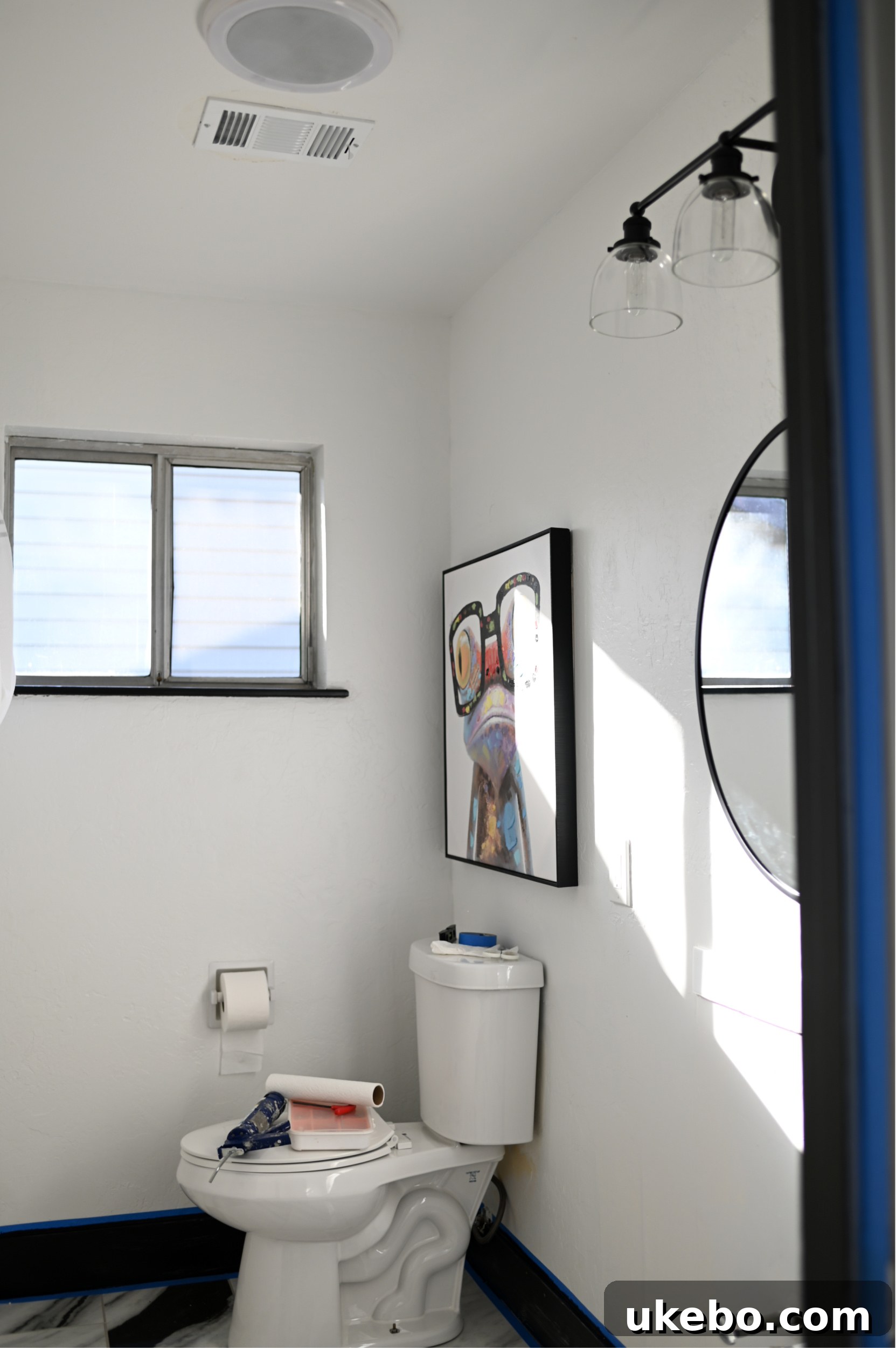 The newly renovated bathroom with QuicTile floor, painted black vanity, and updated fixtures. This is an 'after' shot.