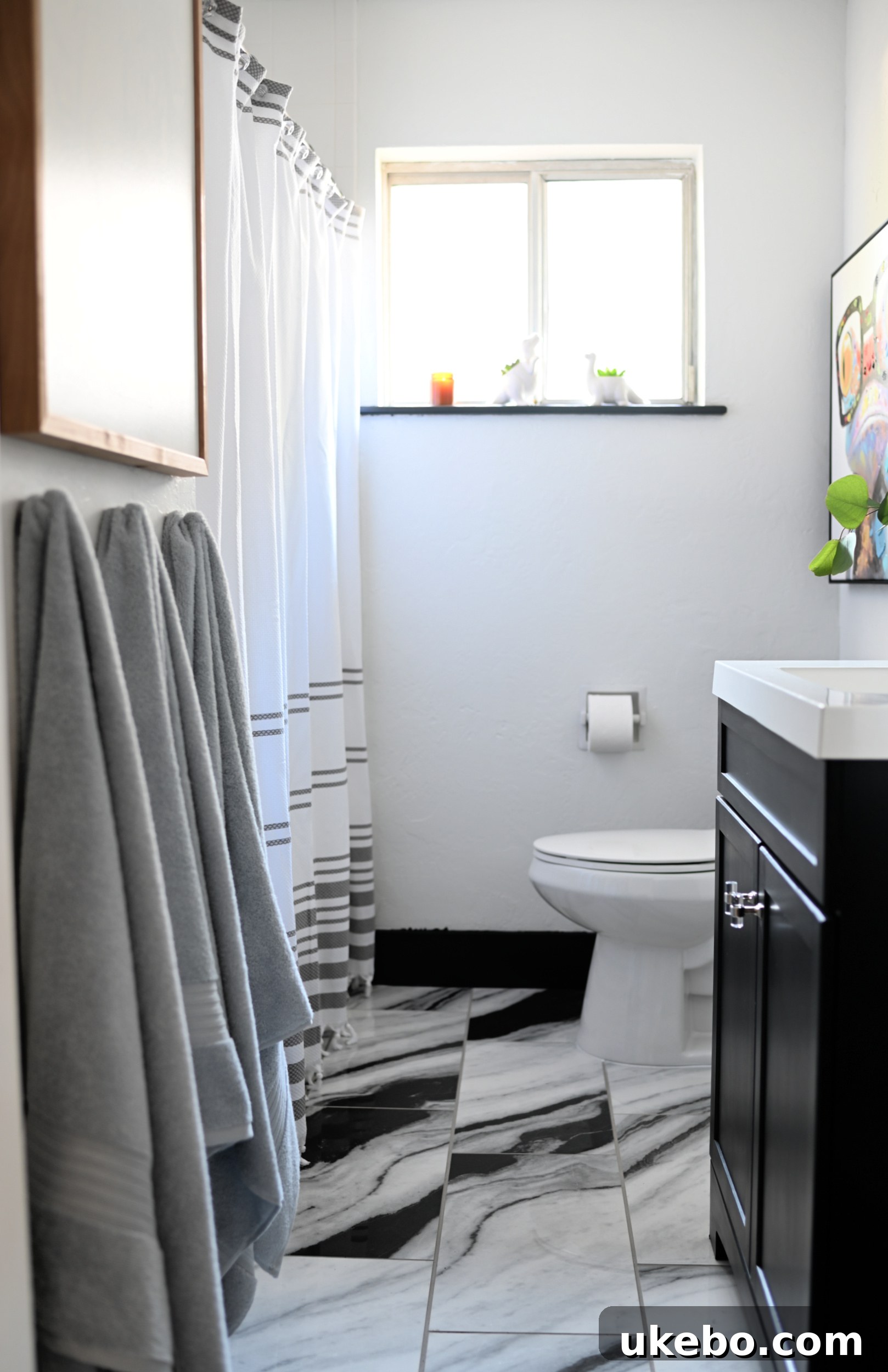 Another 'after' photo of the kids' bathroom, showing the sleek black vanity against the Panda Marble QuicTile and new mirror.