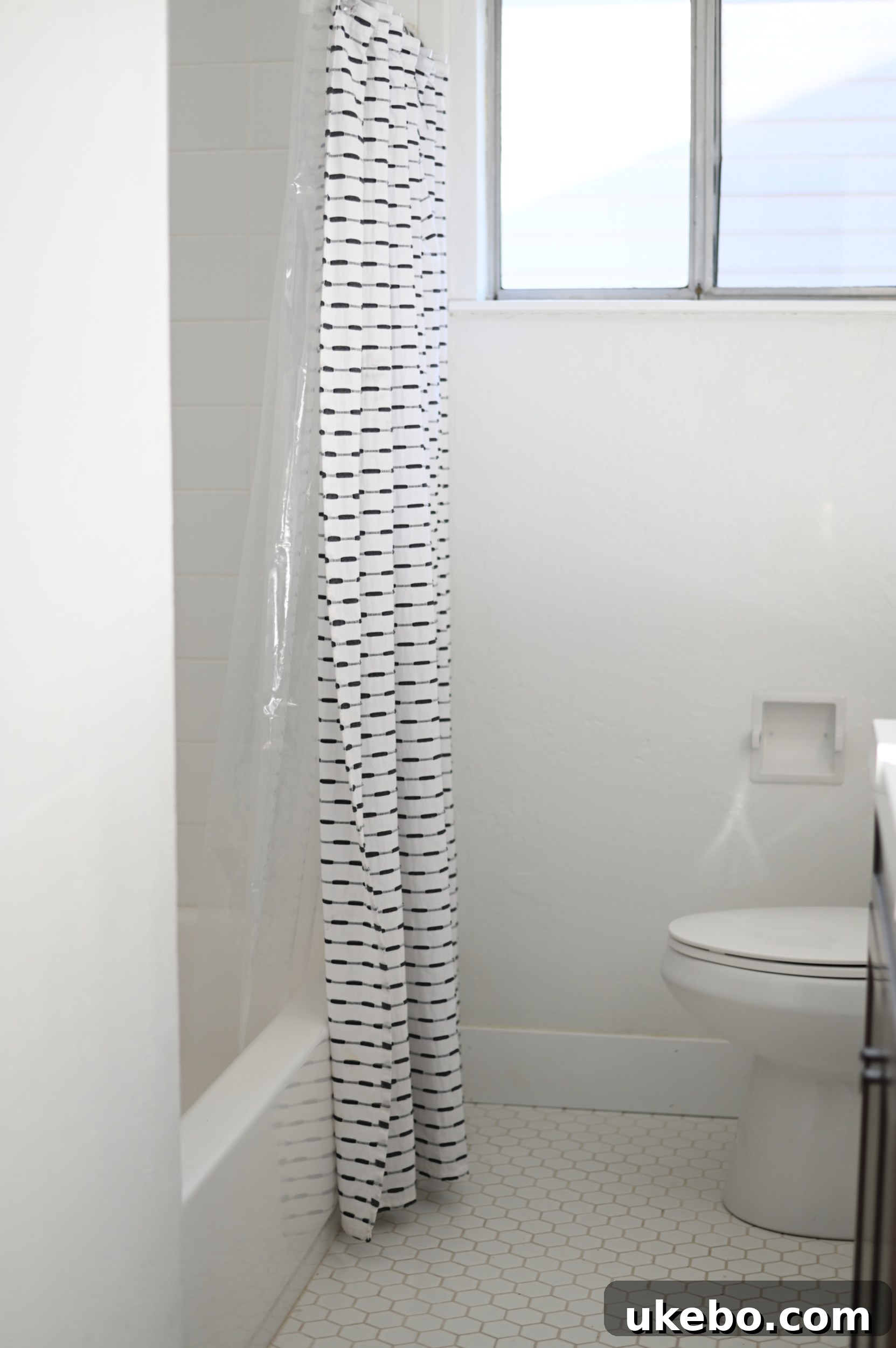 Another view of the old white tile bathroom before renovation, showing the vanity and mirror.