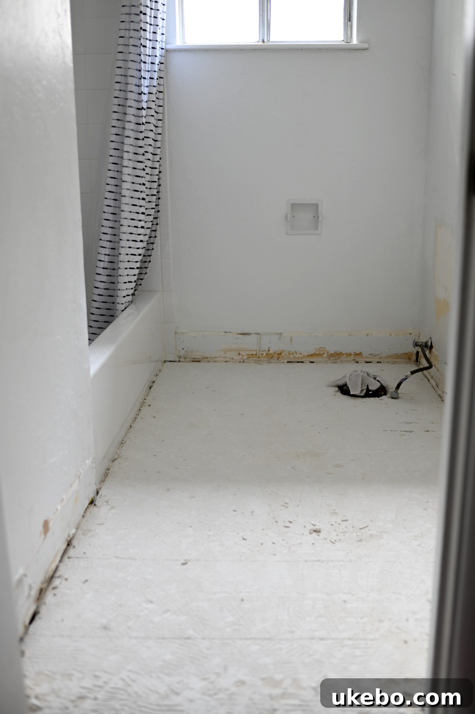 An image showing the old white tiles being removed from the bathroom floor.