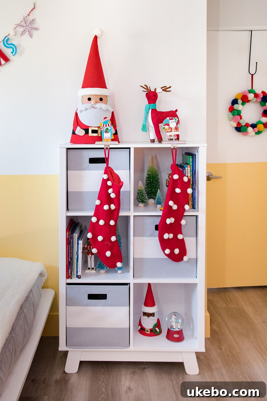 Corner of the twins' room with a small Christmas tree and holiday decorations, creating a festive atmosphere for play.