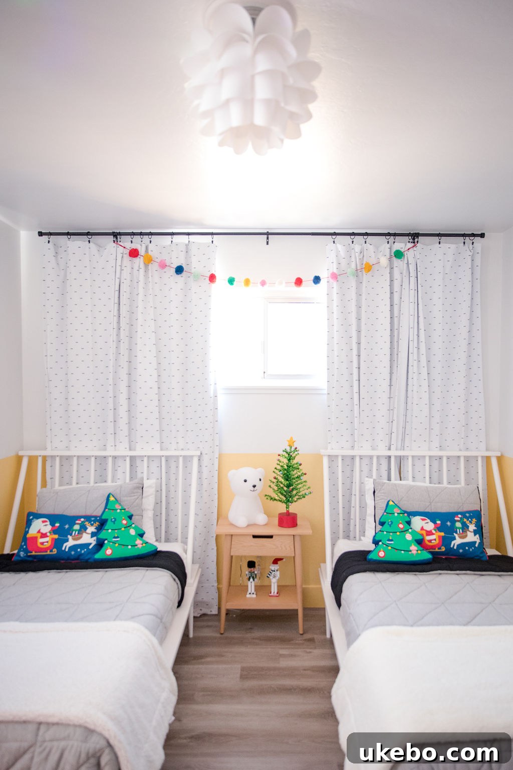 After photo: Transformed twins' bedroom, bright and fun with cheerful yellow walls and extensive holiday decor, part of a kids bedroom makeover.