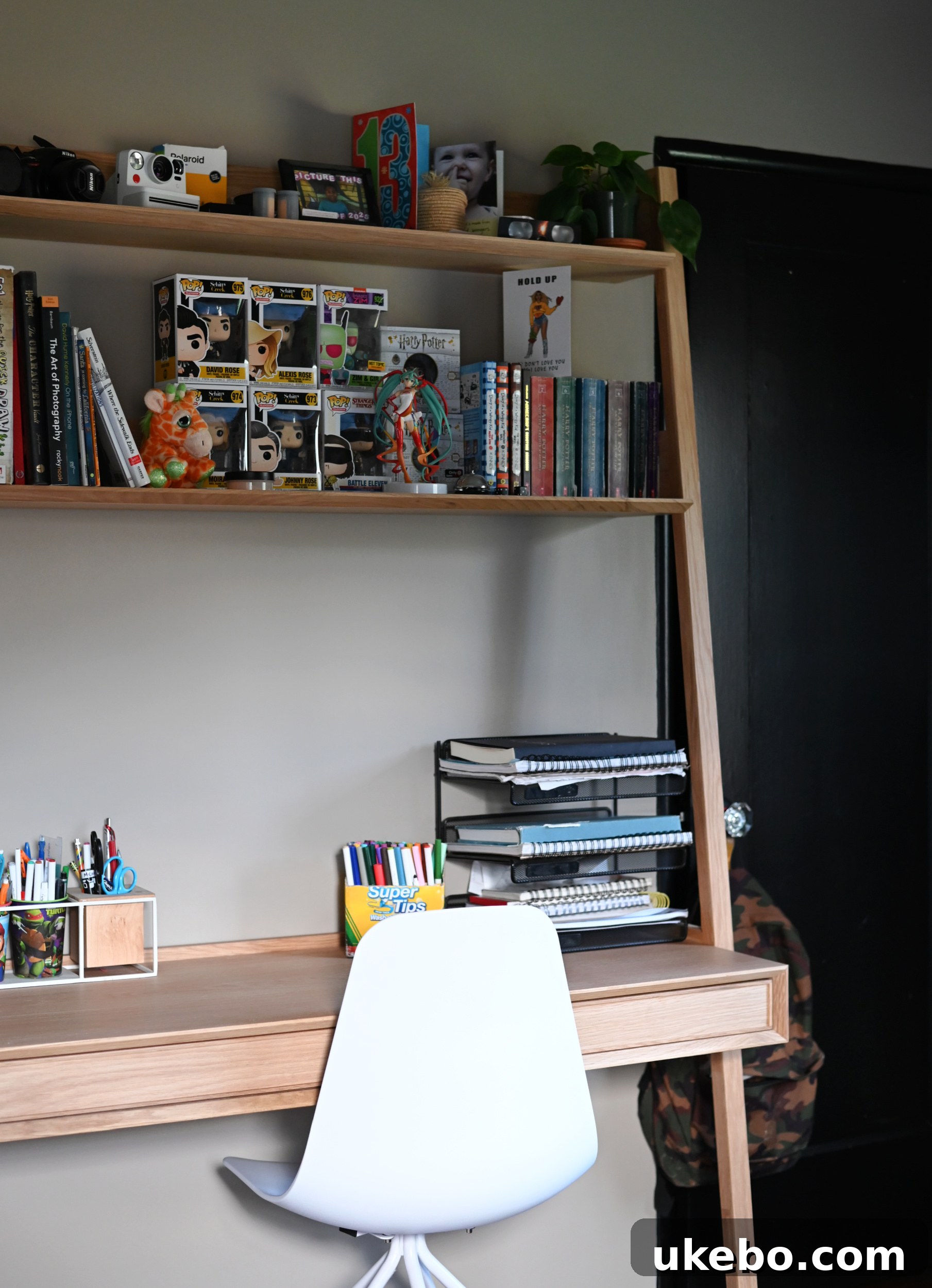 Detailed view of Michael's functional desk area with an integrated hutch and open shelving.