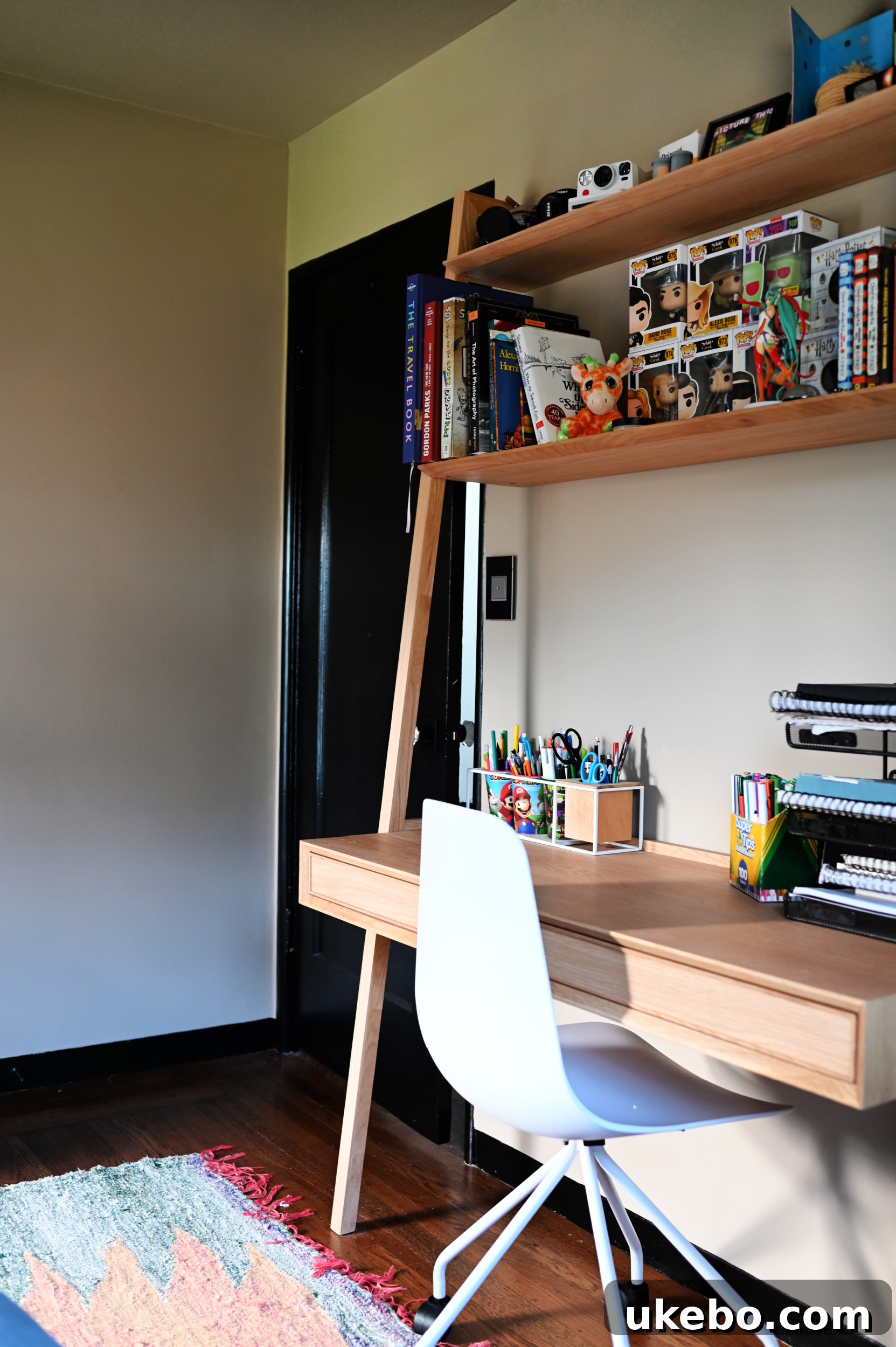 Michael's Modern Neutral Teen Bedroom Makeover 12 Michael's study zone showing books, a plant, and personal items organized on the desk and shelves.