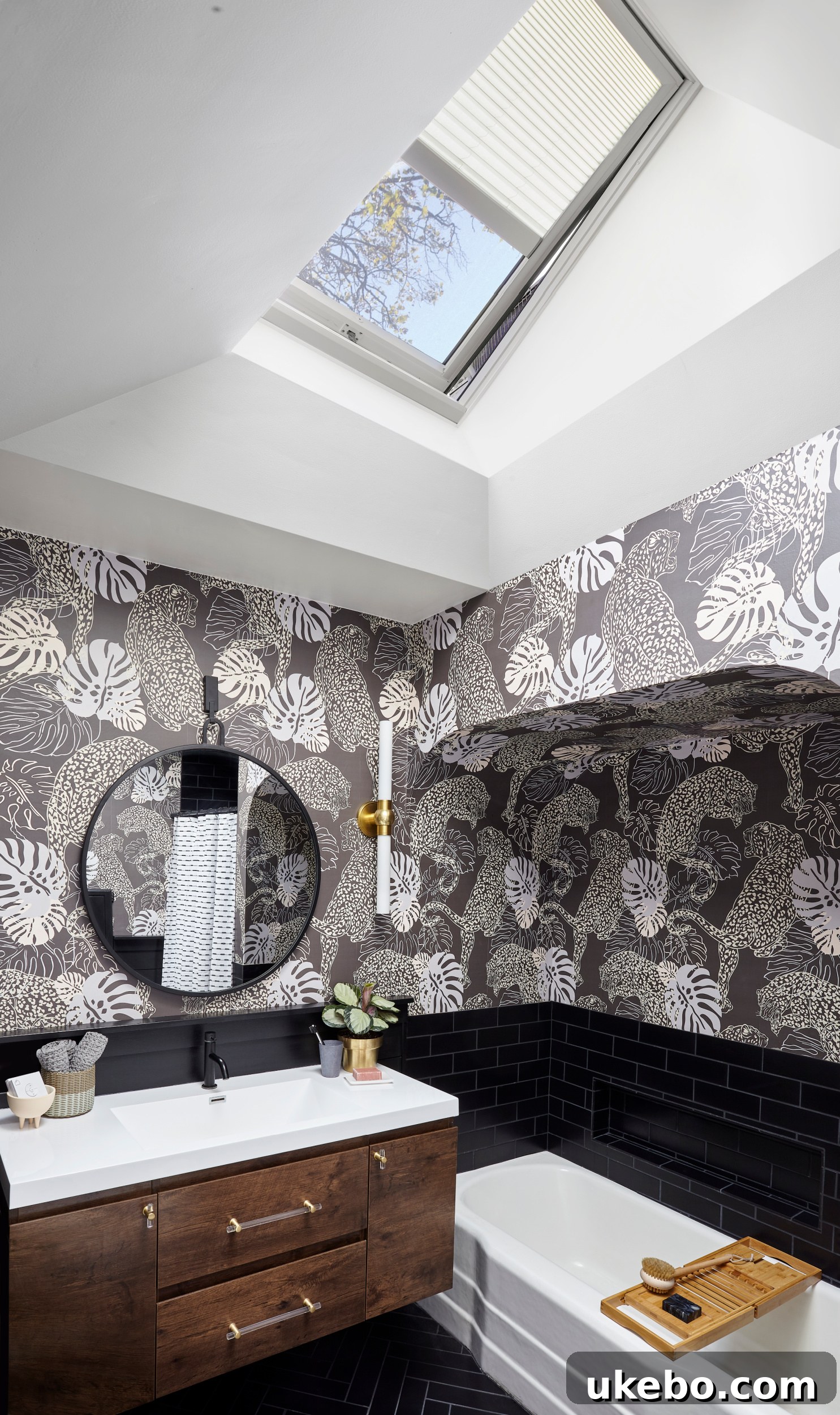 Modern bathroom with a large VELUX skylight overhead, featuring black tiles and bold wallpaper.