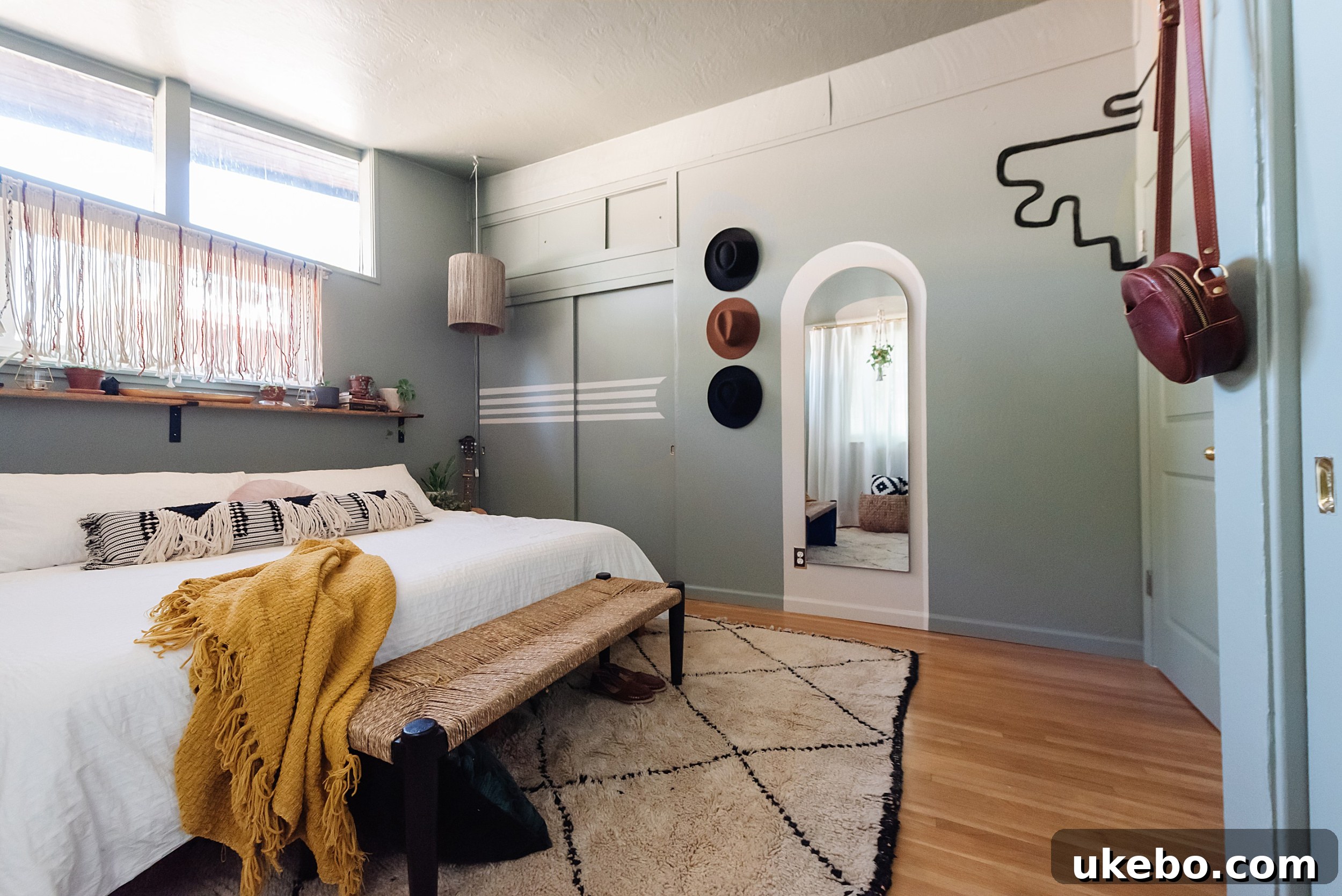 Another view of the transformed primary bedroom, showcasing the calming effect of Evergreen Fog paint and natural textures.