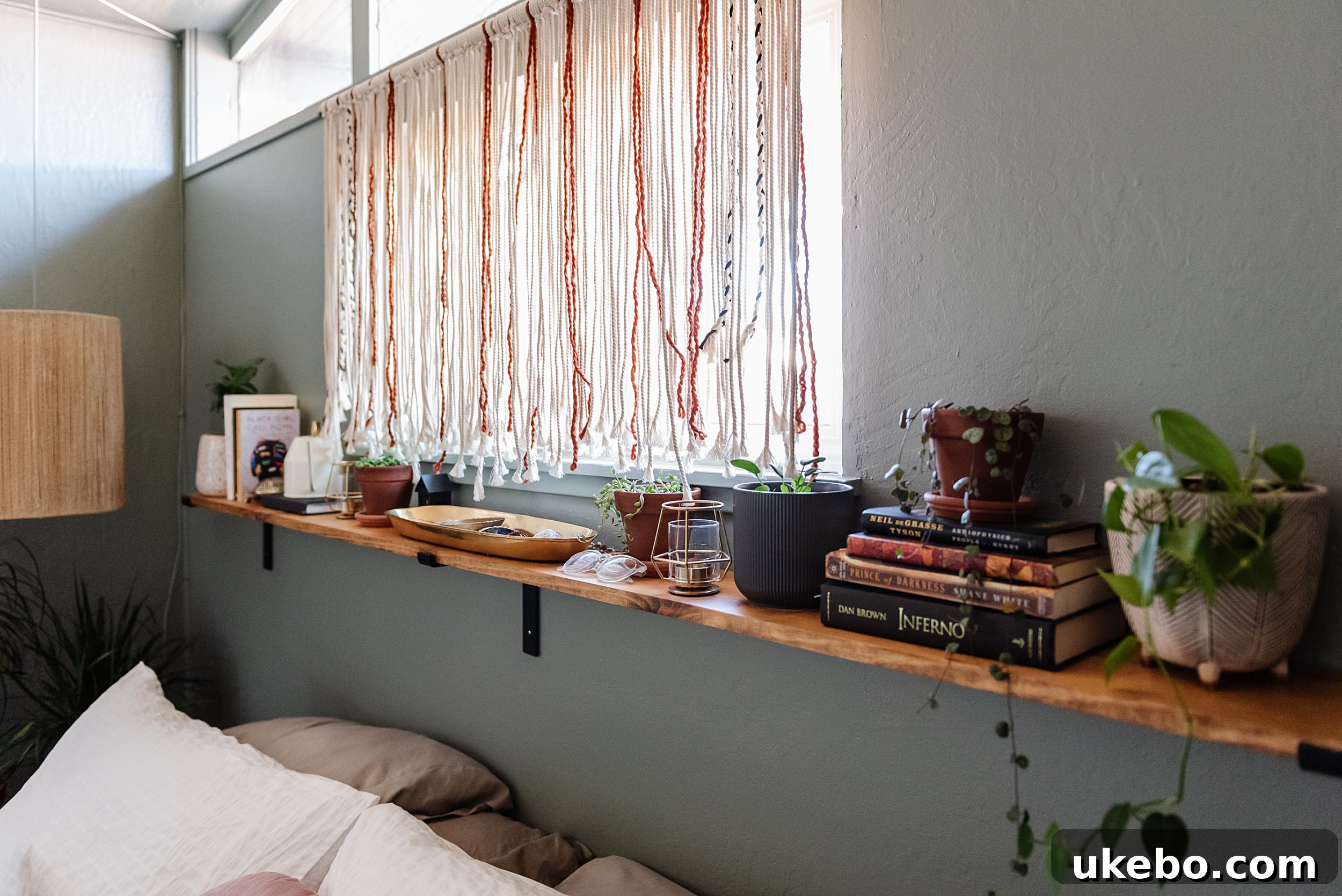 Accent decor and a plant on a nightstand in the freshly painted Evergreen Fog bedroom, showing how small details enhance the theme.