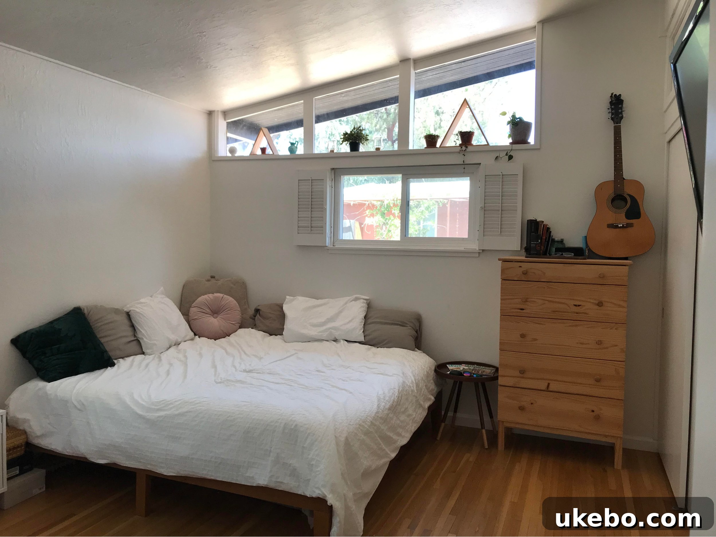 Before photo of a primary bedroom with plain white walls and minimal furniture, highlighting the initial blank canvas.