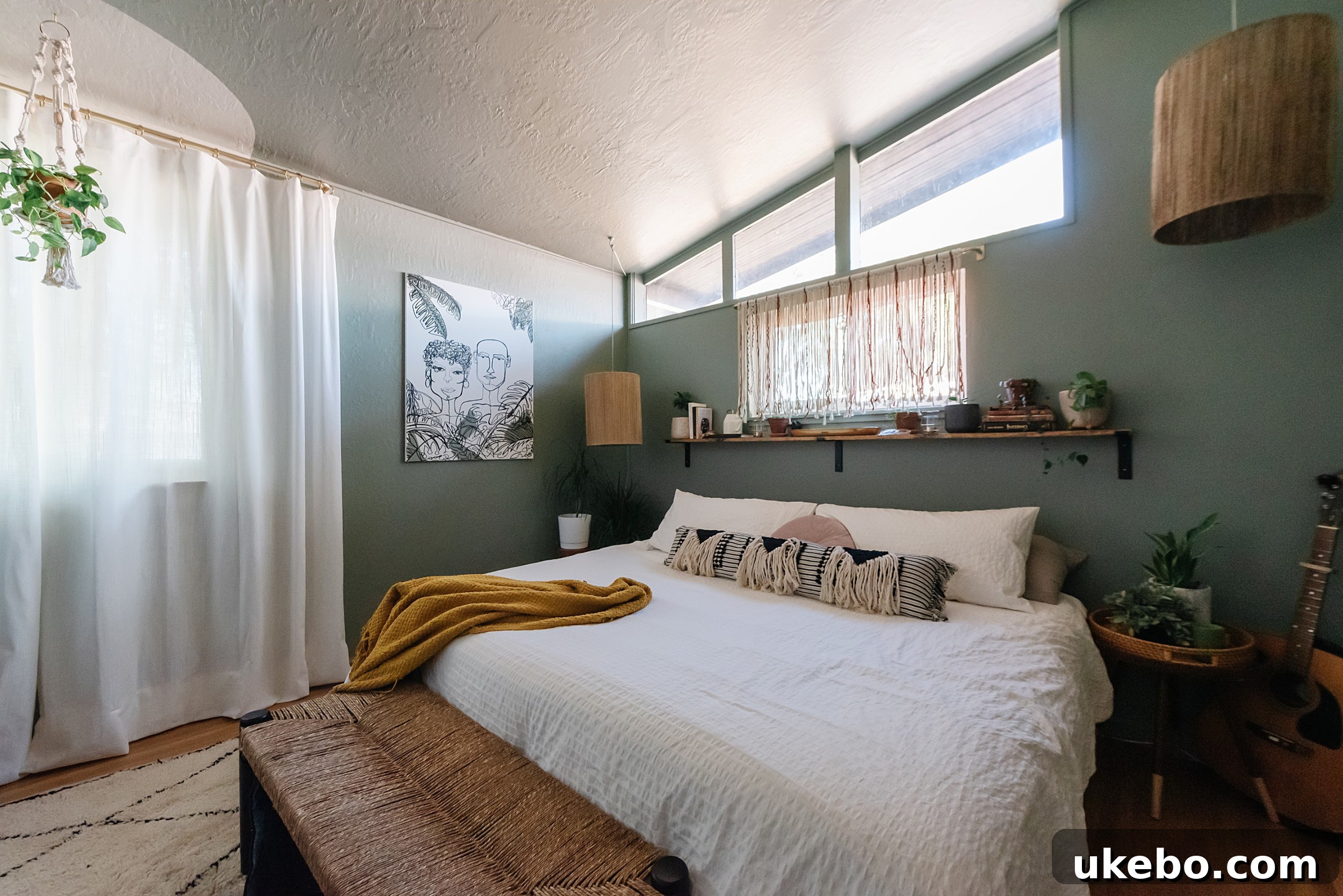 After photo of the primary bedroom, showing walls, trim, and ceiling painted in Sherwin-Williams Evergreen Fog, creating a serene ambiance.