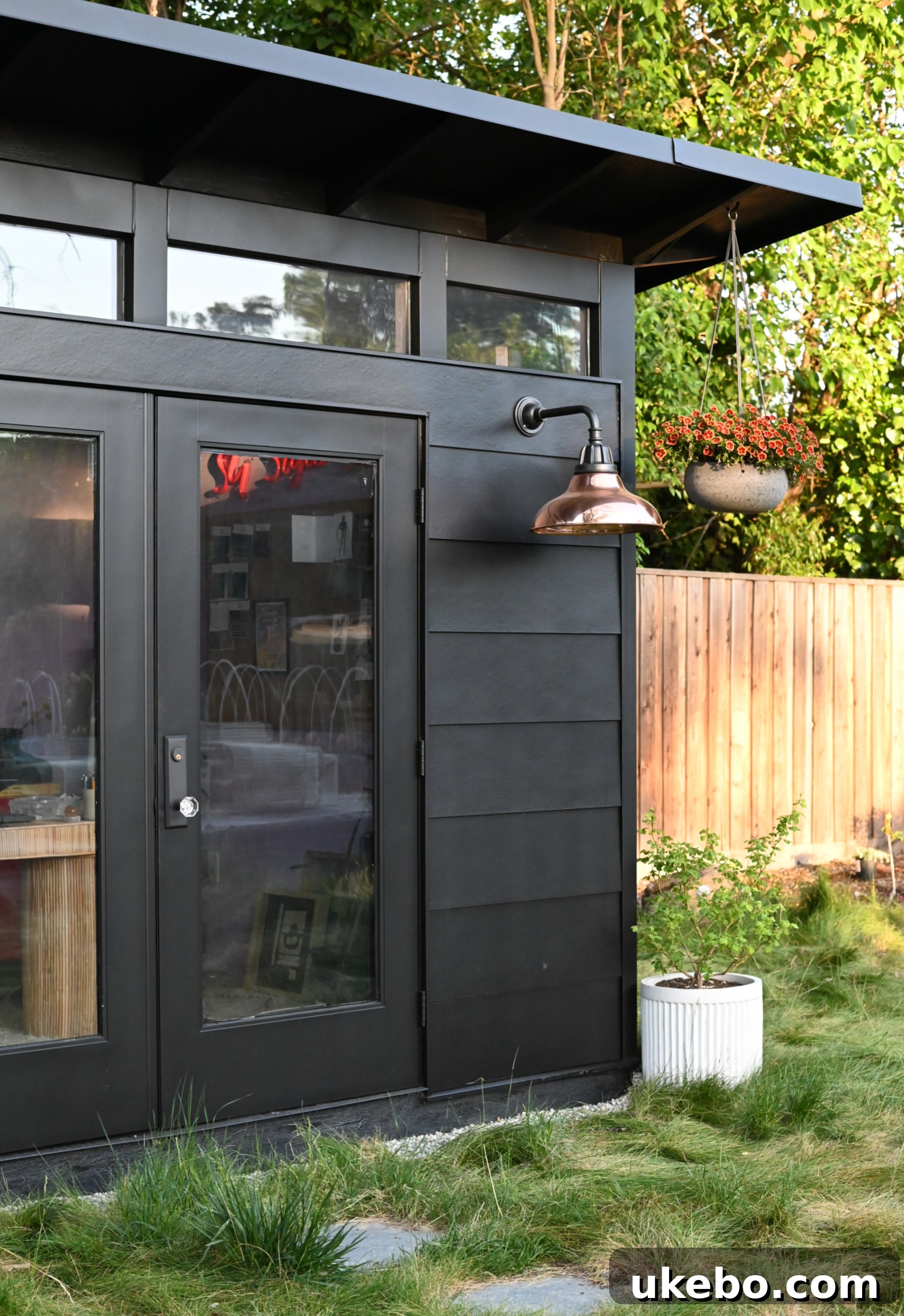 Side view of the backyard studio undergoing painting, showing the rich black color taking shape.