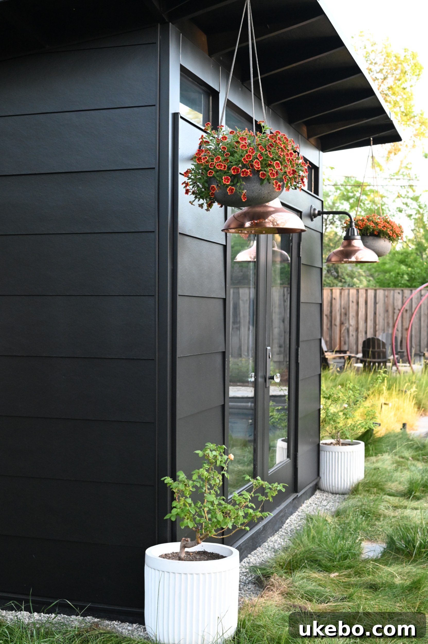 The studio exterior halfway through painting with Tricorn Black, revealing a striking transformation.